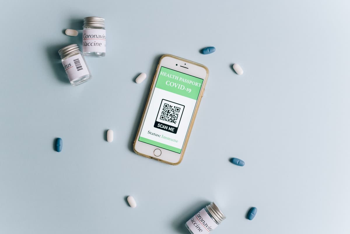 a person holding a smartphone up to a tiny QR code on a tomato