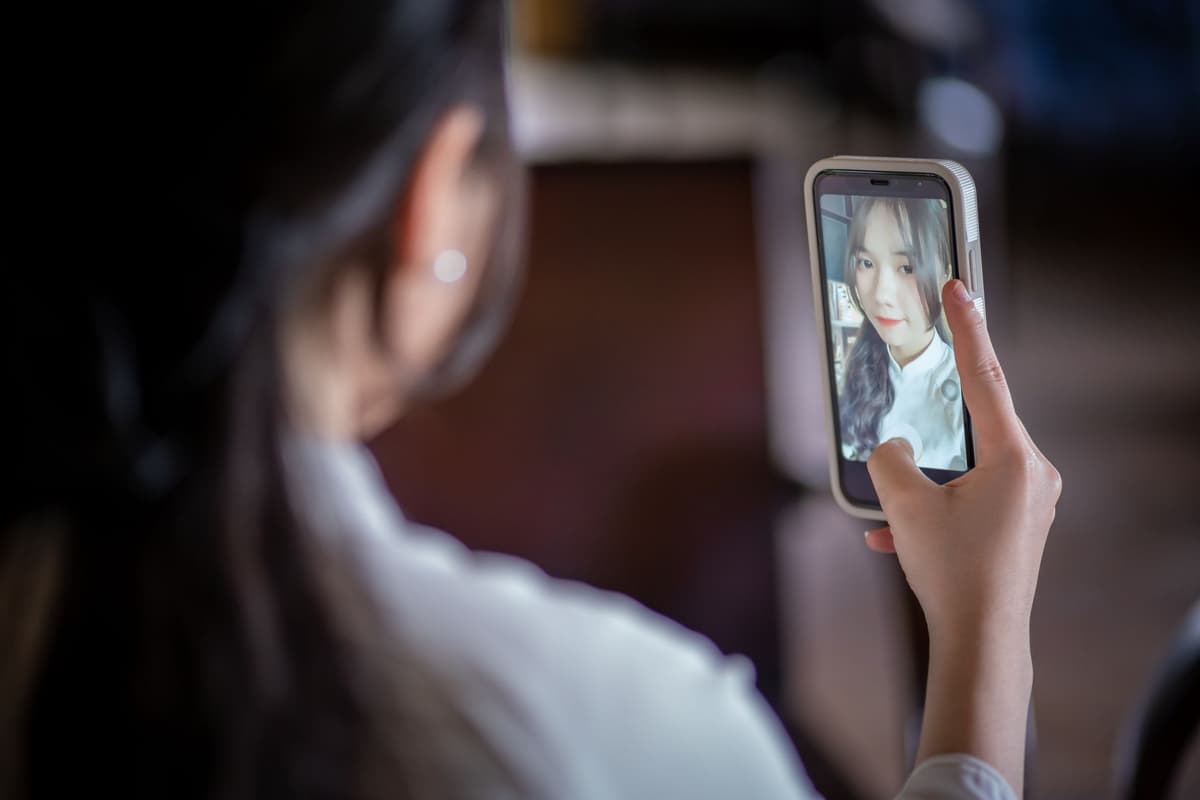 a woman holding a phone camera toward herself