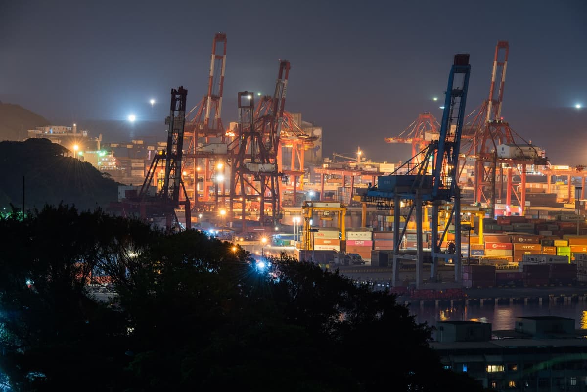 cargo container cranes operating at dusk in a modern industrial port