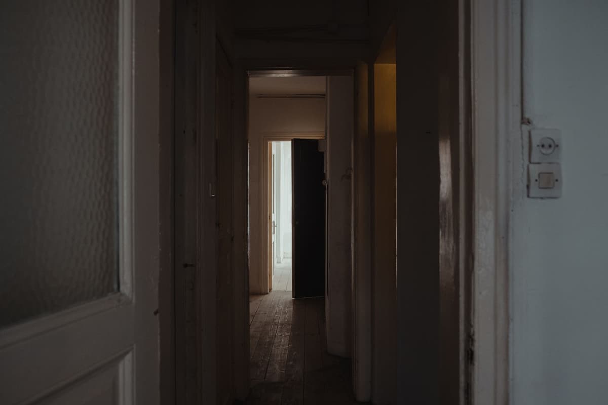 a heavy steel vault door slightly ajar in a dark hallway