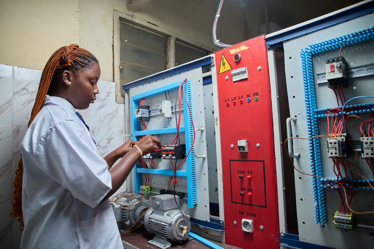 licensed electrician inspecting open breaker panel with voltage tester